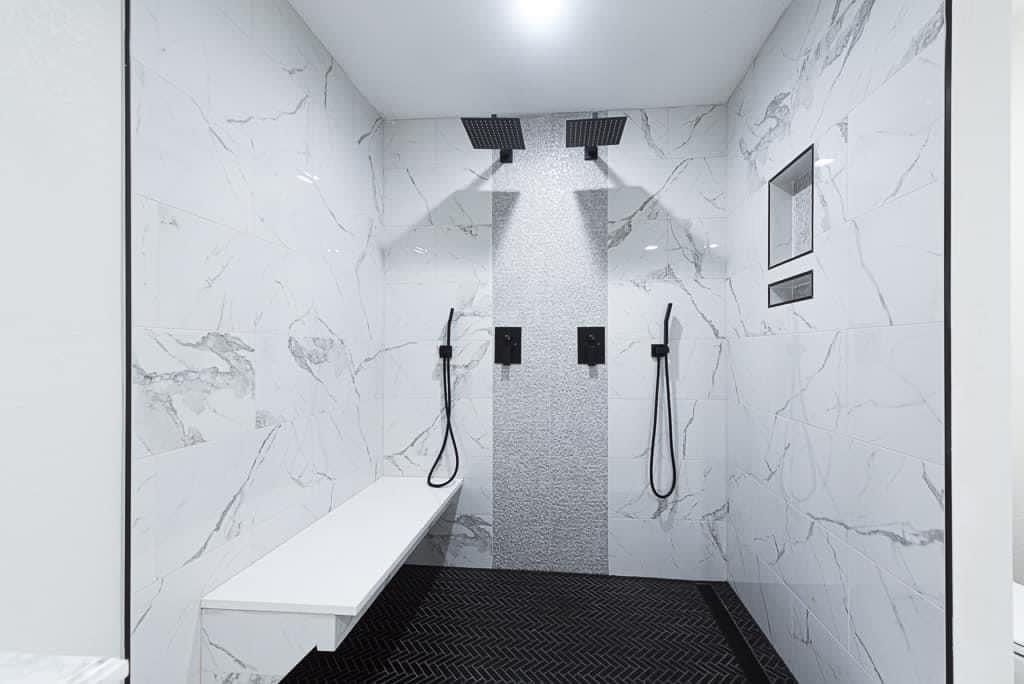 Custom dual-head marble walk-in shower with floating bench