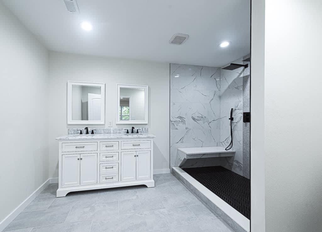 Bright master bath with double vanity and walk-in marble shower